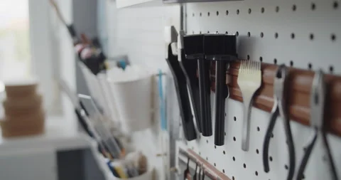Close-up of a man's hand taking a strap end punch off a tools wall Stock Footage 144890228