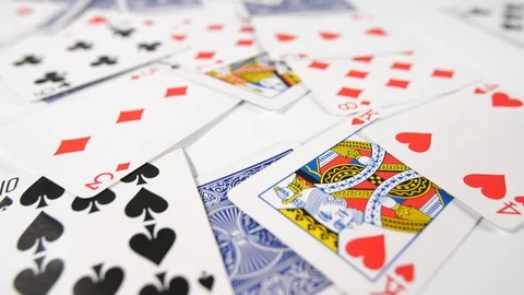 Close up of a mans hand throwing dice onto playing cards with a white surface Stock Footage 89186794