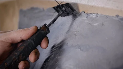 A close-up of a man's hand with a tool. A professional removes the form from the Stock Footage 124479612
