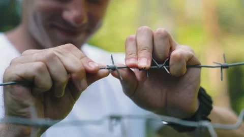 Close-up of Mans hand touching barbed wire in prison. Stock Footage 157072662