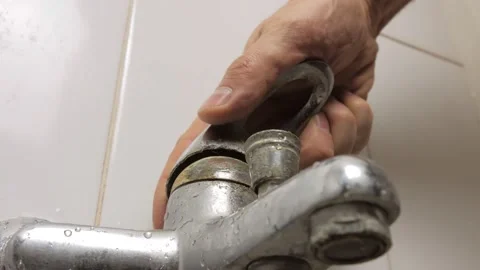 Close-up of a man's hand turning the broken lever of a water faucet Stock Footage 169133370