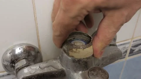 Close-up of a man's hand turning the broken lever of a water faucet Stock Footage 169538648