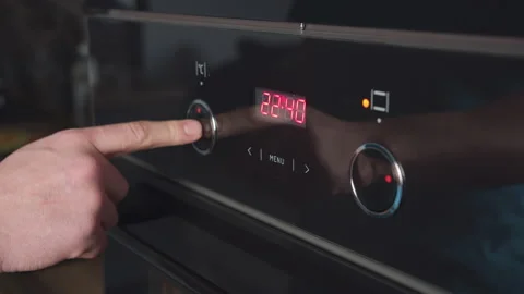 Close-up of a man's hand turning the handle of the oven. The man switches modes Stock Footage 159690910