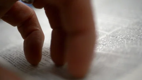 A close-up of a man's hand turning the pages of a dictionary. Stock Footage 99998888