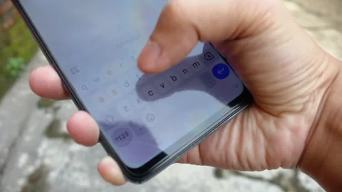 Close up of a man's hand typing text with a smartphone with a bokeh background Stock Footage 321216721