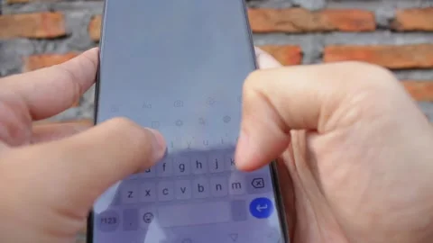Close up of a man's hand typing text with a smartphone with a bokeh background Stock Footage 321216726