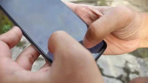 Close up of a man's hand typing text with a smartphone with a bokeh background Stock Footage 321216731