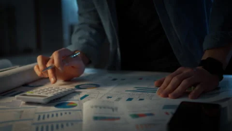 Close-up of a mans hand using a desk calculator with a pen. Paper business c Stock Footage 348319586