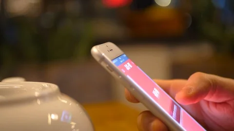 Close-up of man's hand using the phone in a restaurant around a teapot and cups Video stock 128419427