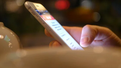 Close-up of man's hand using the phone in a restaurant around a teapot and cups Video stock 128419435