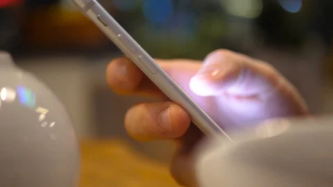 Close-up of man's hand using the phone in a restaurant around a teapot and cups 스톡 동영상 128419478