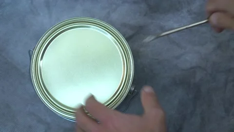Close up of man's hand using screwdriver to open new can of orange paint. DIY. Stock Footage 133529991
