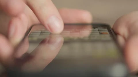Close-up of a man's hand using a smartphone to chat and browse content online. A Vidéo 240841243