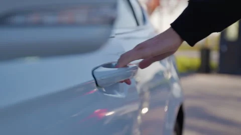Close-up of a mans hand using a smartphone app to remotely control his car. Man Stock Footage 314308076
