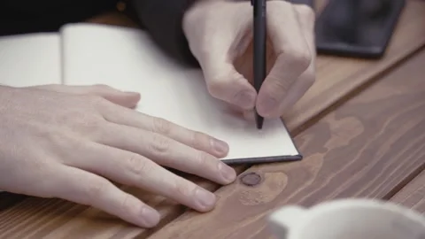 Close-up of a man's hand writes in a notebook Stock Footage 152575454