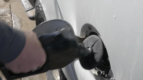 Close-up of a man's hand's and gas pump nozzle filling vehicle. Stock Footage 100641659