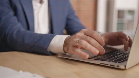 Close-up: Man's hands are typing something on a laptop. Stockbeeldmateriaal 191881081