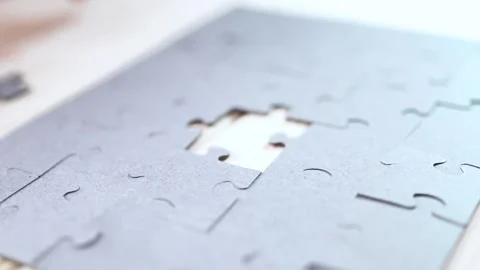 Close-up of Man's Hands Assembling Jigsaw Puzzle on Table. Stock Footage 329929358