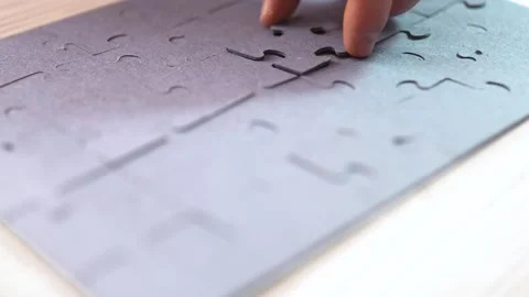 Close-up of Man's Hands Assembling Jigsaw Puzzle on Table. Stock Footage 329929501