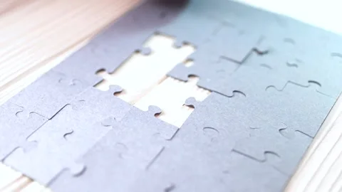 Close-up of Man's Hands Assembling Jigsaw Puzzle on Table. Video stock 329929572