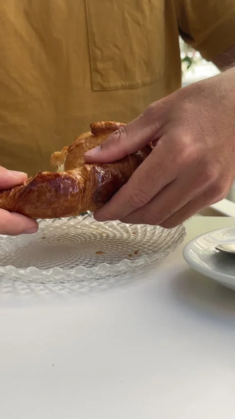 Close up of a man's hands breaking a fresh croissant in two pieces. Delicio.. Stock Footage 338443806