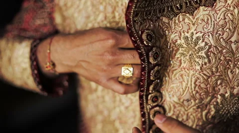 Close-up of man's hands buttoning up Hindu wedding suit Stock Footage 68717050