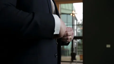 Close up of a mans hands buttoning up a suit jacket on wedding day. HD 24FPS. Stock Footage 150709040