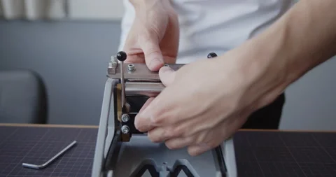Close-up of a man's hands changing blade in a leather splitter Video stock 146139626