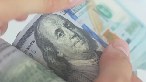 Close-up of a man's hands counting hundred dollar bills on a white background Видео 94761856