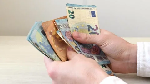 A close-up of a mans hands counting a stack of euro banknotes. Successful deals Stock Footage 341568326