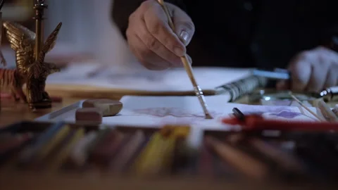 Close-up of a man's hands drawing with a brush. Artist creating a watercolor  Stock Footage 152344779