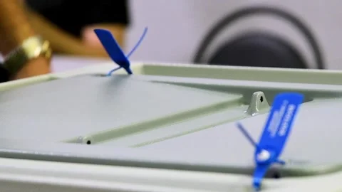 Close-up of a man's hands dropping sheets of paper or a ballot into a votin.. Stock Footage 328830097