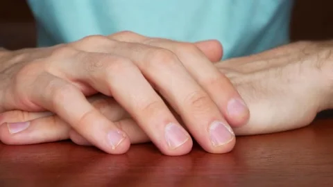Close up of mans hands folded on a table drumming on it with fingers nervously Stock Footage 140827731