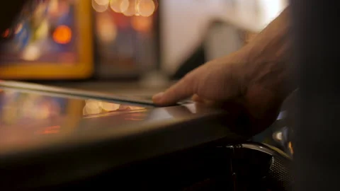 Close-up on a man's hands getting frustrated while playing pinball at an arcade 스톡 동영상 130990376