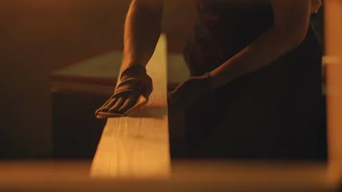 Close up of man`s hands grinding plank with sandpaper in workshop during the Stock Footage 114696029