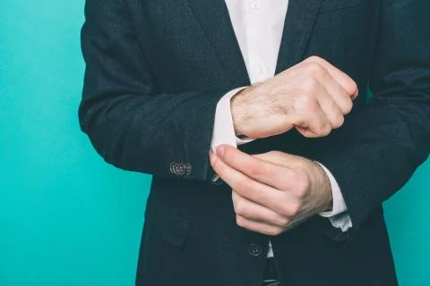 Close up of man's hands. Guy is locking the button at the edge of the shirt Stock Photos