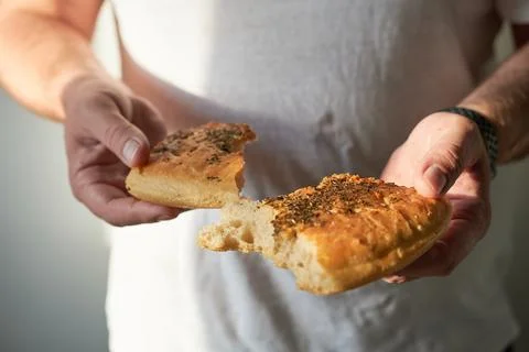 Close-up of a man's hands holding bread with spices. Stock Photos