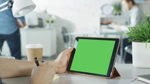 Close-Up of a Man's Hands Holding Green Screen Tablet Computer and Making Notes  Stock Footage 70853065
