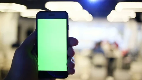 Close-Up of a Man's Hands Holding Green Screen Smartphone a. In the Background Stock Footage 73839406