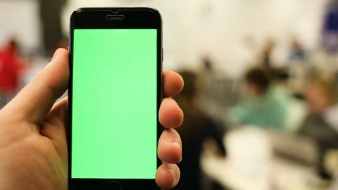 Close-Up of a Man's Hands Holding Green Screen Smartphone a. In the Background Stock Footage 73839415