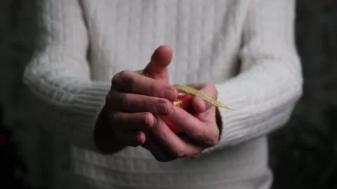 Close-up of a man's hands holding out a red gift box. Gift giving concept. Stock Footage 166269807