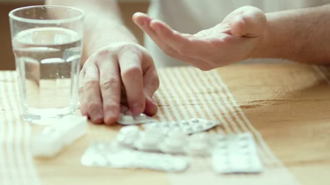 Close Up of Man's Hands Holding Pill and Taking it with Glass of Water 4K 10-bit Stock-Footage 332677377