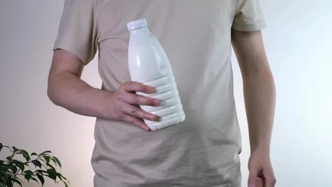 Close-up of a mans hands holding a plastic bottle of milk, yogurt or other dairy Stock Footage 313323701