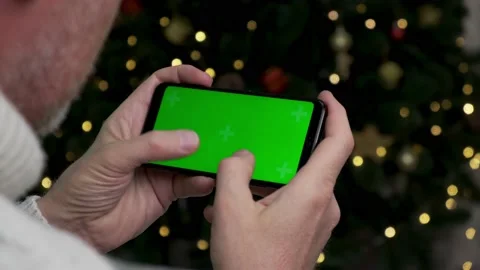 Close-up of man's hands holding smartphone with green screen in horizontal mode. Stock Footage 165710043