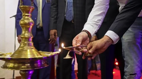 Close-up of a man's hands lighting a large oil lamp with a smaller oil lamp.. Stock Footage 297938572