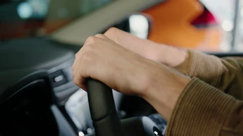 Close-up of a man's hands lying on the steering wheel of a new car Stock Footage 200931401