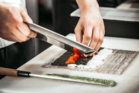 Close-up man`s hands making rolls in restaurant. Fotos Stock