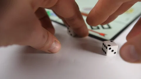 Close up of mans hands moving dice on a board game of red and green home shape Stock Footage 89188553