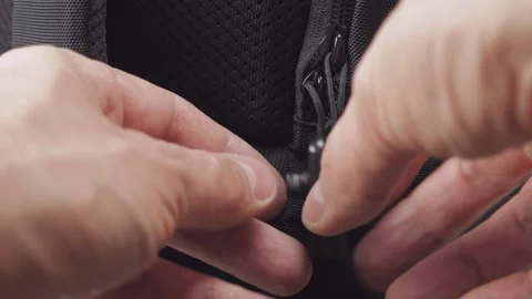 Close-up of a man's hands opening a backpack with anti-theft protection Stock Footage 166084319