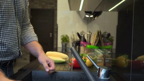 Close up on man's hands peeling and washing radishes. Slider shot. 库存影片 70574602
